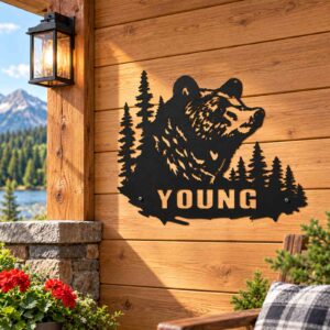 Personalized Black Bear Forest Name Sign installed in a realistic outdoor setting; Bear and pine forest metal sign with sample YOUNG name installed on cabin siding.